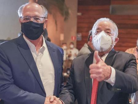  Alckmin e Lula de máscara, vestes formais, em aperto de mão.